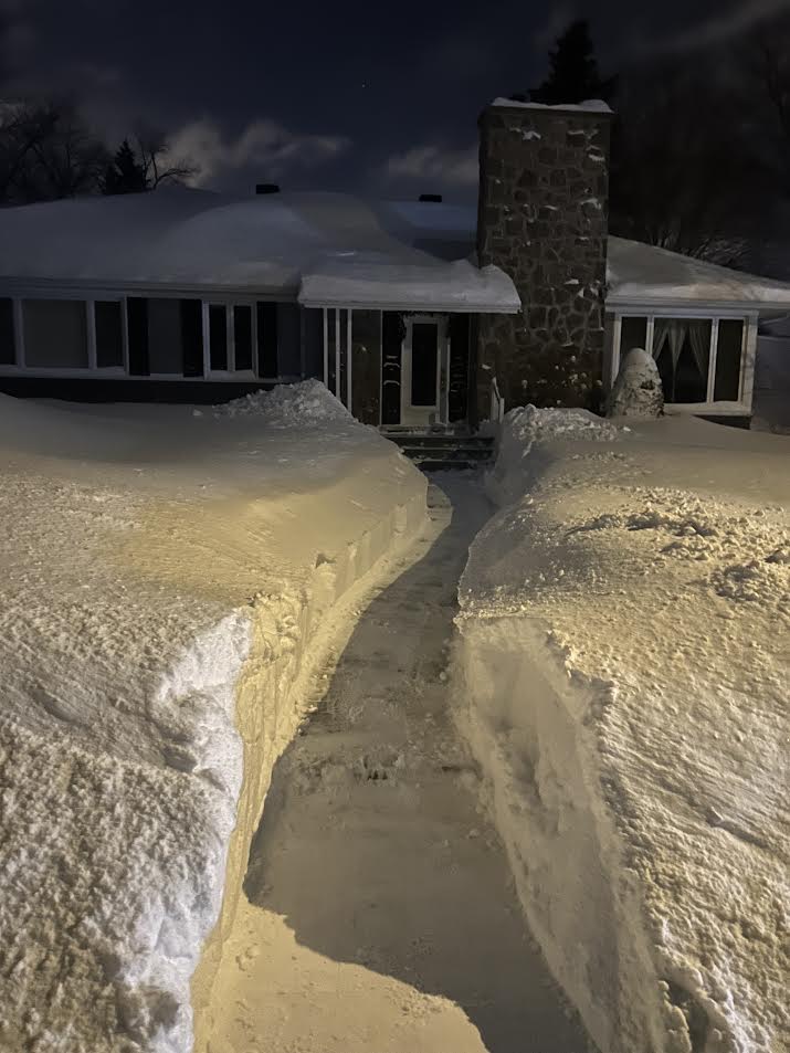 Passage déneigé devant une maison