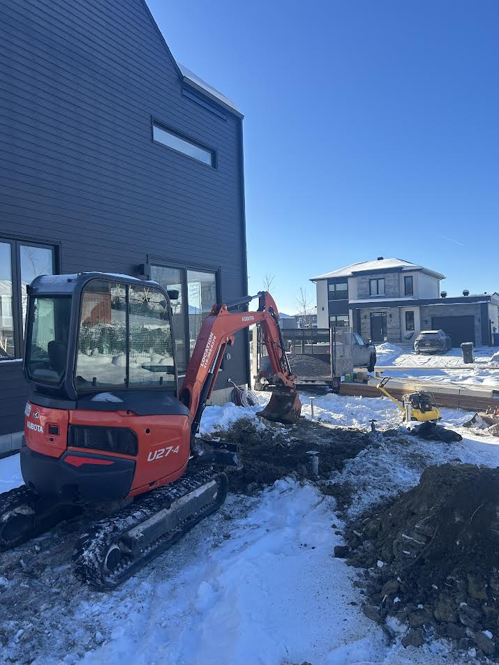 Pelle mécanique sur un chantier d’excavation résidentiel en hiver